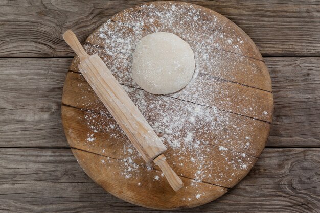 Matterello con pasta per pizza e farina sul tagliere