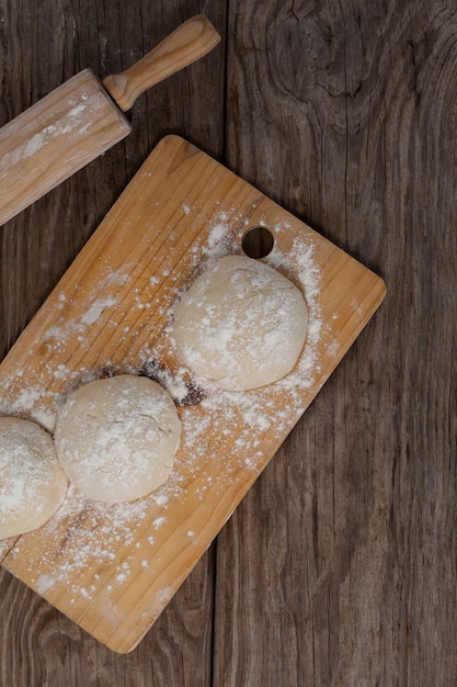 Matterello con pasta per pizza e farina sul tagliere