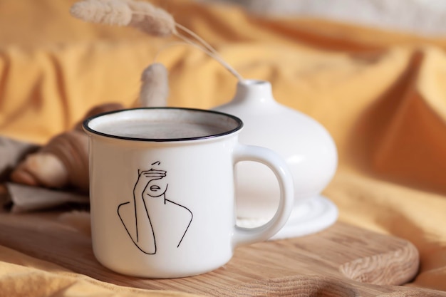 Mattina a letto, cornetto e caffè con il latte