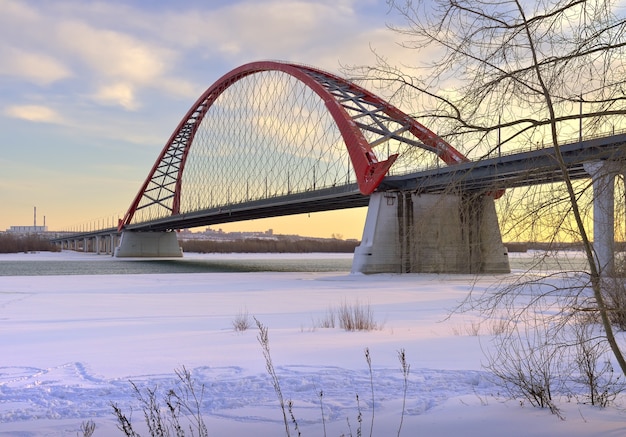 Mattina d'inverno sull'Ob L'arco del ponte automobilistico Bugrinsky sulla sponda del fiume ghiacciato