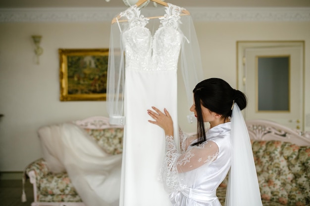 Mattina della sposa I compensi della sposa La sposa ammira e tocca il suo vestito