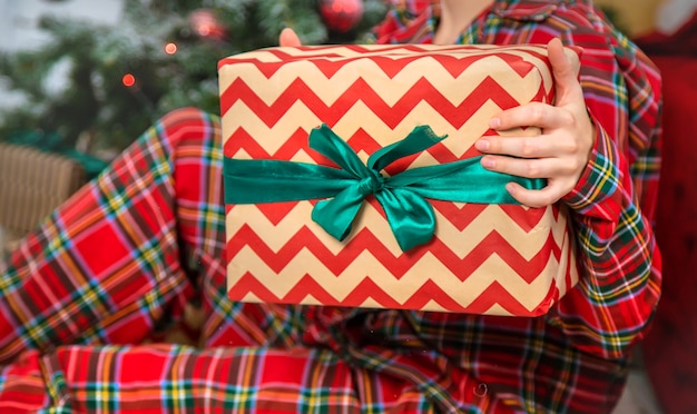 Mattina di Natale, ragazza con doni nelle sue mani. Messa a fuoco selettiva.