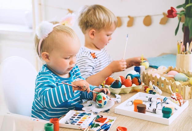 Mattina di Pasqua Bambini piccoli che dipingono le uova Famiglia che si prepara per la Pasqua Dipinge pennarelli decorazioni per colorare le uova per le vacanze Sfondo creativo per la scuola materna e la scuola materna