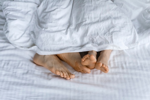 Mattina e risveglio con i piedi sotto le coperte a letto la mattina