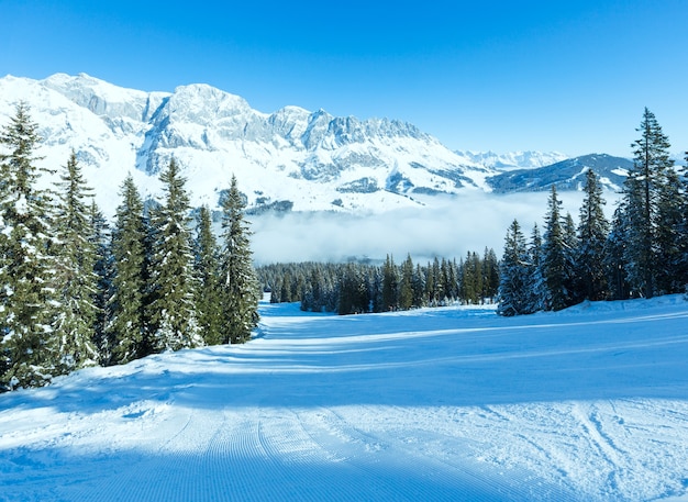 Mattina inverno paesaggio di montagna con nuvole nella valle sottostante (regione di Hochkoenig, Austria)