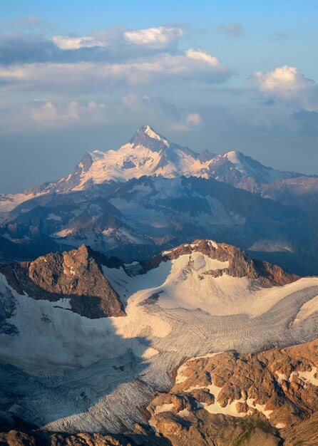 Mattina nelle montagne del Caucaso. Vette innevate, ghiacciai. Luce del sole nascente