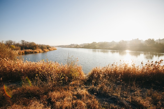 Mattina presto. Lago d'autunno bello e colorato nei raggi del sole. Sfondo autunnale.