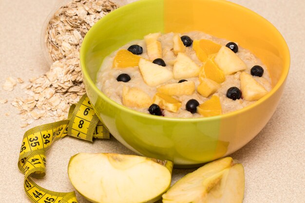 Mattina sana alimentazione, struttura dietetica con porridge di farina d'avena, frutta e metro. Colazione perfetta prima dell'allenamento