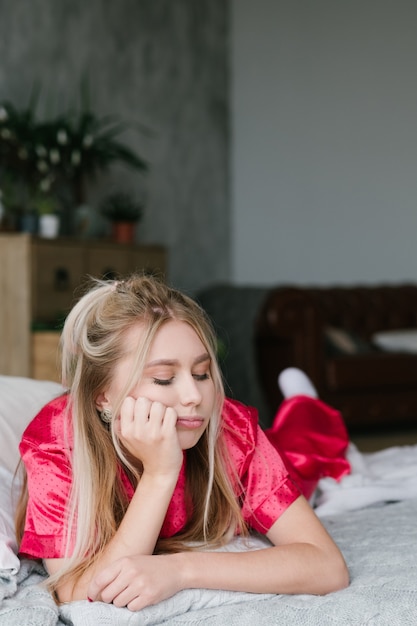 Mattina sveglia. Donna bionda sconvolta annoiata a letto