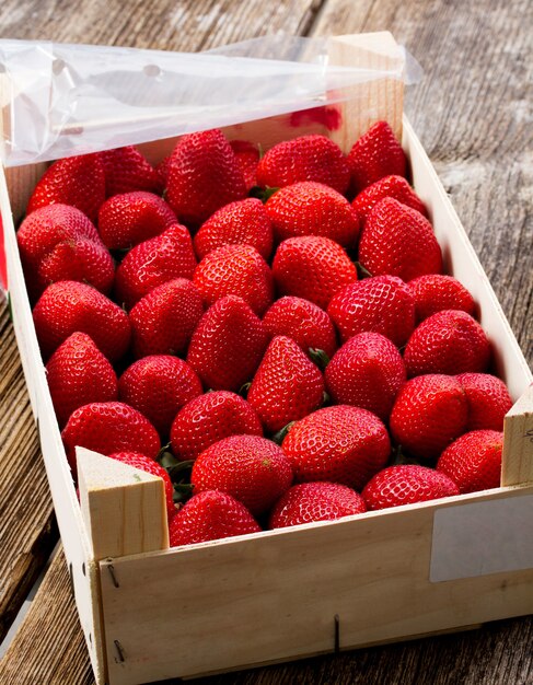 Matura della fragola rossa fresca in cassa di legno