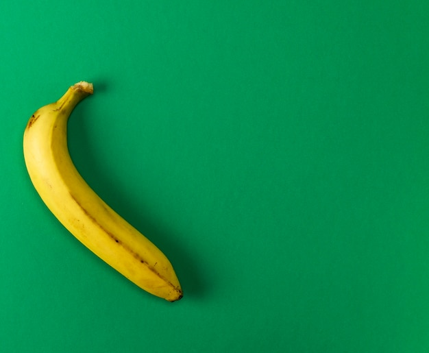 Maturo giallo una banana su uno sfondo verde