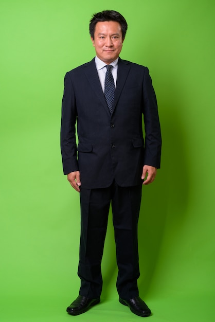 Maturo uomo d'affari giapponese su sfondo verde