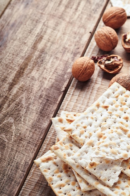 Matza e noci. Pane ebraico rituale tradizionale su fondo rustico di legno vecchio. Cibo pasquale. Concetto di celebrazione della festa ebraica di Pesach.