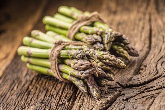 Mazzetto di asparagi freschi su tavola in rovere rustico.