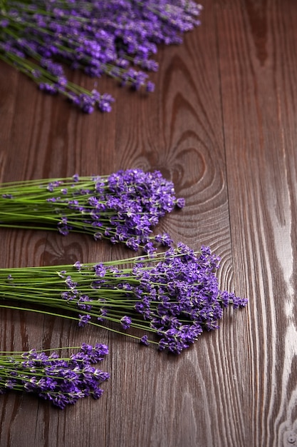 Mazzi di fiori di lavanda sul tavolo in legno marrone laici piatta