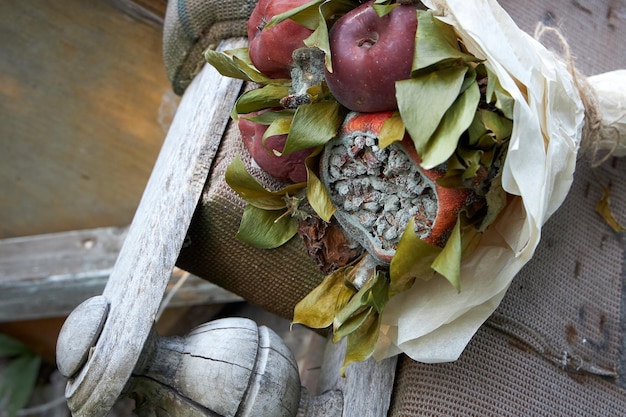 Mazzi di frutta marcia e fiori appassiti giacciono sui resti di vecchi mobili