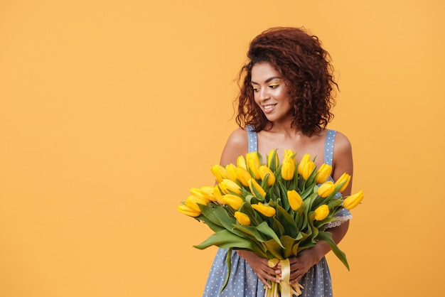 Mazzo africano sorridente della tenuta della donna dei fiori