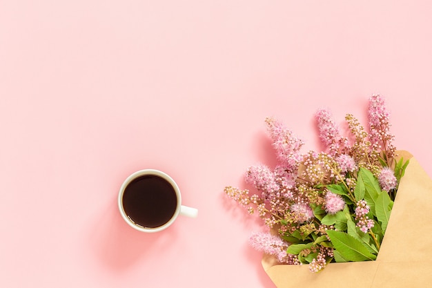 Mazzo dei fiori dentellare in busta, tazza di caffè e una scheda in bianco bianca per testo su priorità bassa dentellare