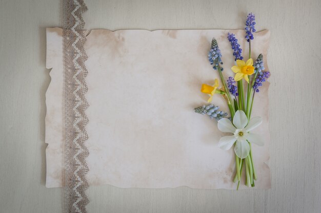 Mazzo dei narcisi e dei fiori del muscari su un di legno