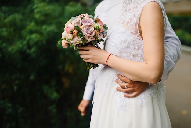 Mazzo del fiore di cerimonia nuziale nelle mani della sposa