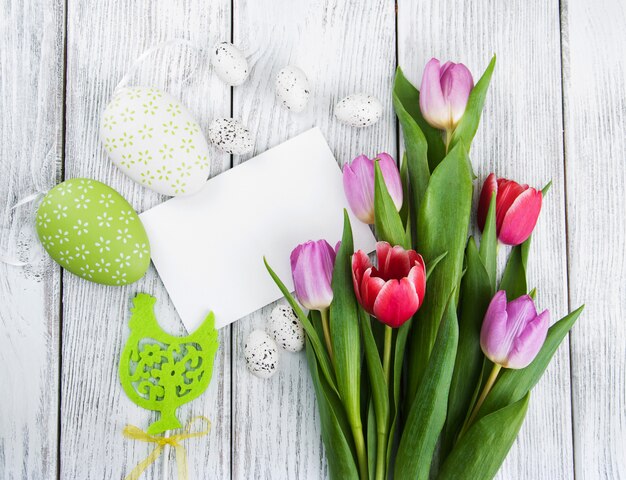 Mazzo del tulipano e carta di pasqua accogliente in bianco