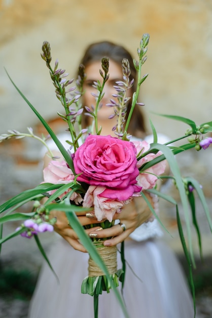 Mazzo della tenuta della mano della donna dei fiori freschi