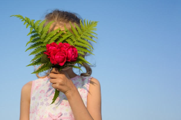 Mazzo della tenuta della ragazza del bambino dei fiori di rosa