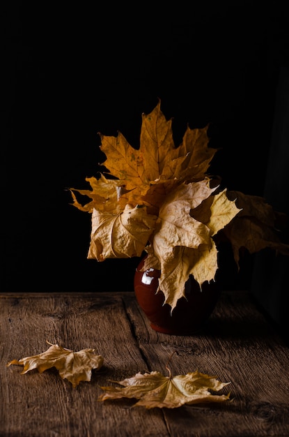 Mazzo delle foglie cadute autunno in un vaso di argilla