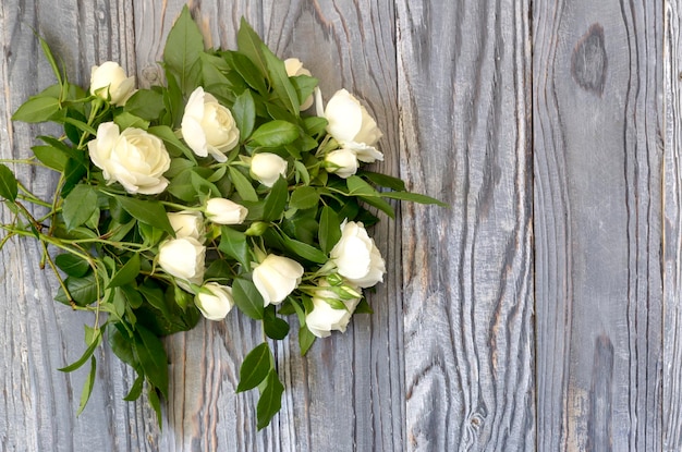 Mazzo delle rose fragranti tenere bianche su un fondo di legno