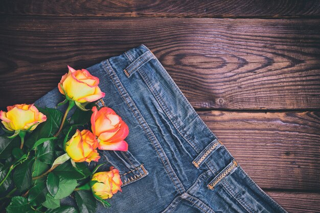 Mazzo delle rose gialle fresche che si trovano sulle blue jeans