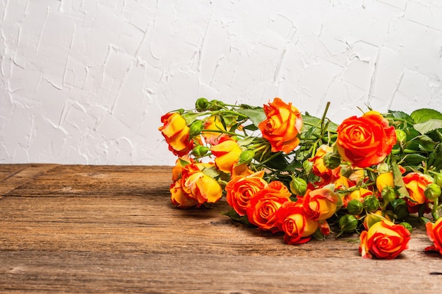 Mazzo delle rose gialle luminose sulla vecchia tavola di legno