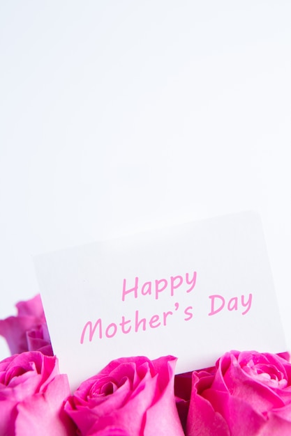 Mazzo delle rose rosa con la carta felice di giorno di madri nel rosa