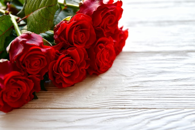 Mazzo delle rose rosse e su un bianco di legno. Concetto di San Valentino