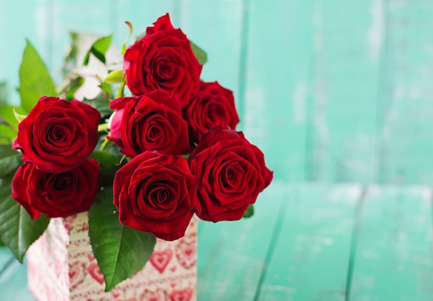 Mazzo delle rose rosse su una tavola di legno.