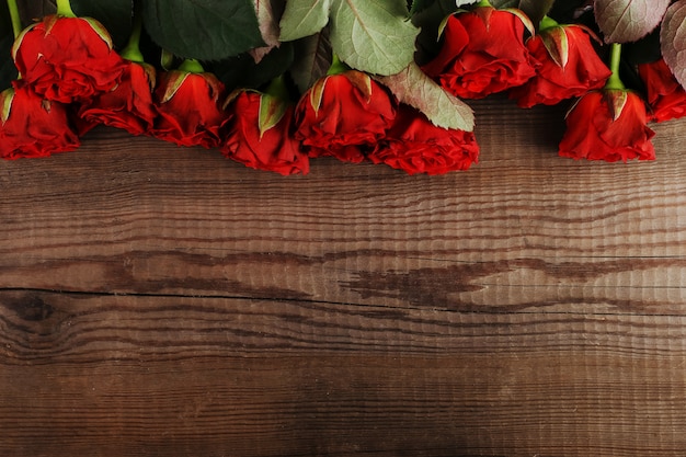 Mazzo delle rose rosse sulla tavola di legno