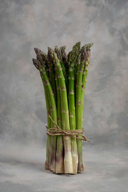 Mazzo di asparagi verdi isolati su grigio. Verdure fresche.