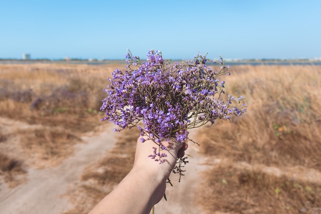 Mazzo di bei fiori viola in mano della donna