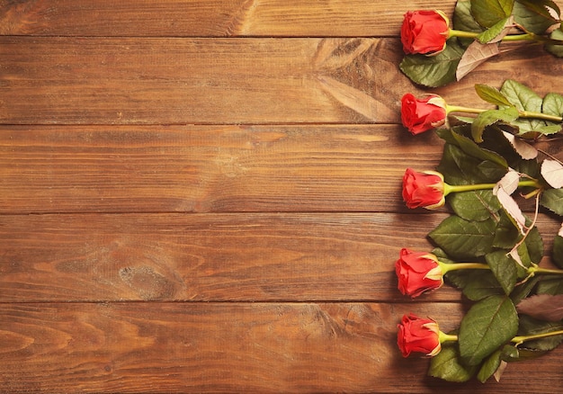 Mazzo di belle rose rosse su fondo di legno