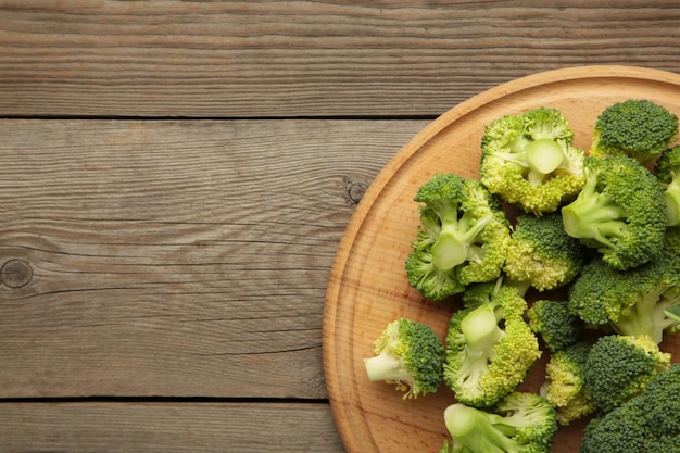 Mazzo di broccoli verdi freschi sul tagliere su fondo di legno grigio. Vista dall'alto.