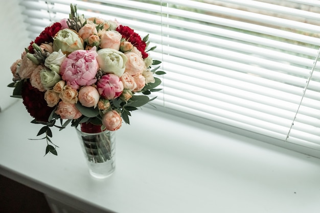 Mazzo di cerimonia nuziale in un vaso sulla finestra. matrimonio, relazioni familiari, accessori per matrimoni.