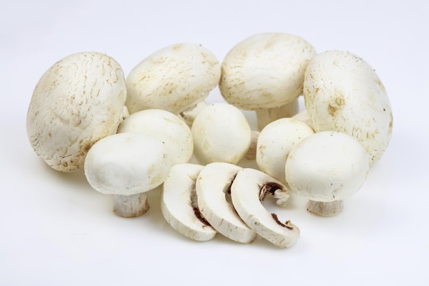 Mazzo di champignon con alcune fette su sfondo bianco