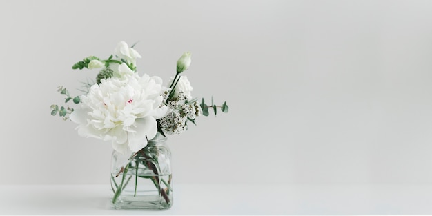 Mazzo di fiori bianchi in un vaso sgomberato