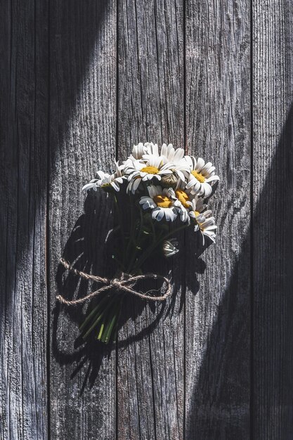 Mazzo di fiori di campo su fondo di legno grigio alla luce del sole