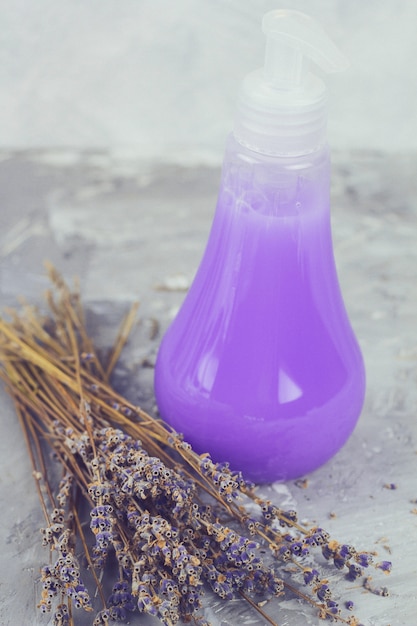 Mazzo di fiori di lavanda secchi e un prodotto cosmetico con colore e profumo di lavanda in bottiglia