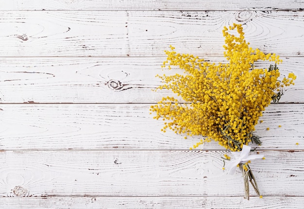 Mazzo di fiori di mimosa gialla su bakground di legno