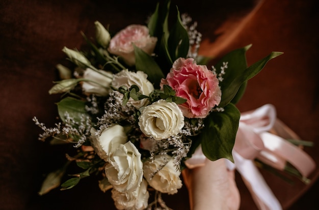 Mazzo di fiori freschi su uno sfondo di tessuto marrone con un posto per il testo