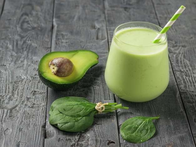 Mazzo di foglie di spinaci, avocado e frullati su un tavolo di legno. Prodotto fitness. Nutrizione sportiva dietetica.