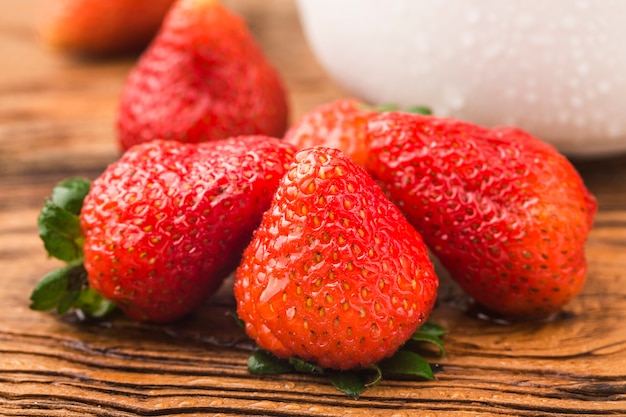 Mazzo di fragole fresche sul fondo del bordo di legno