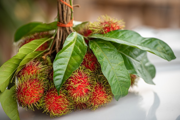 Mazzo di frutti freschi maturi del Rambutan con le foglie verdi.