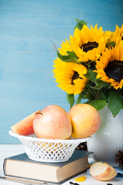 Mazzo di girasoli in vaso bianco con mele